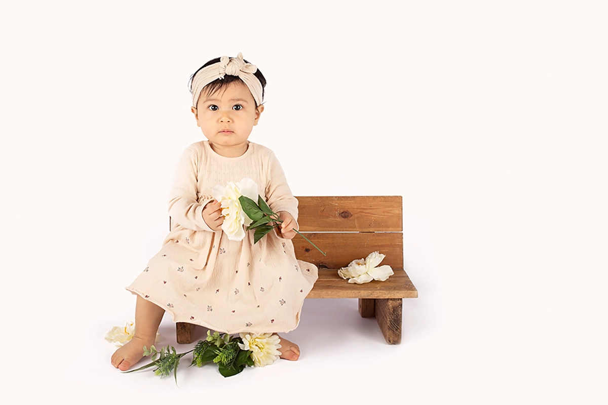 Sitter fotoshoot in Maassluis met meisje op bankje en bloemen