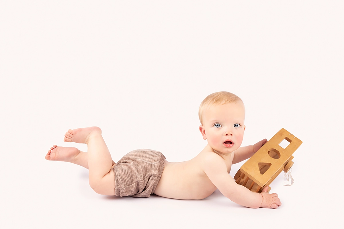 Maassluis fotoshoot sitter baby spelend met treintje